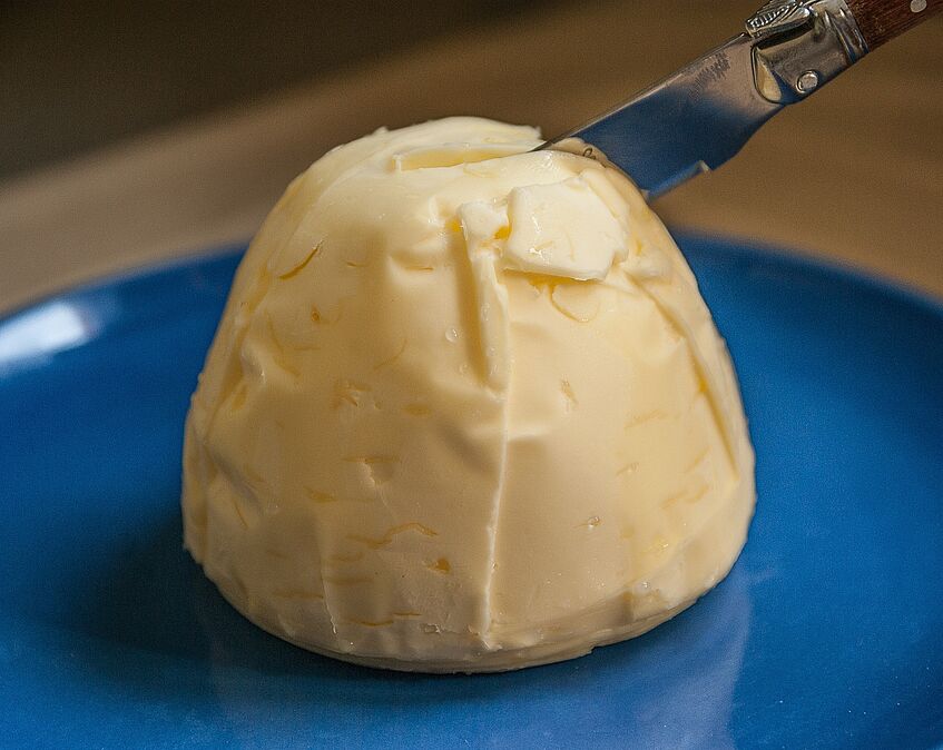 Ein Stück Butter, in dem ein Messer steckt